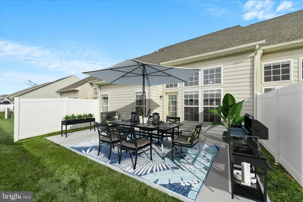 a view of a patio with table and chairs under an umbrella