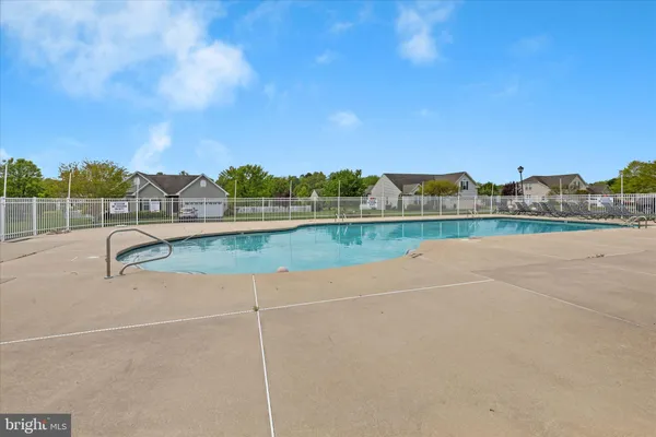 a green field with big trees and a wooden fence
