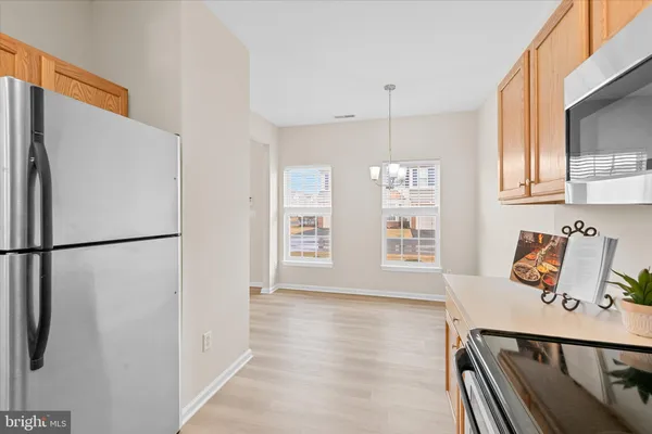 a view of a kitchen with a refrigerator cabinets and wooden floor