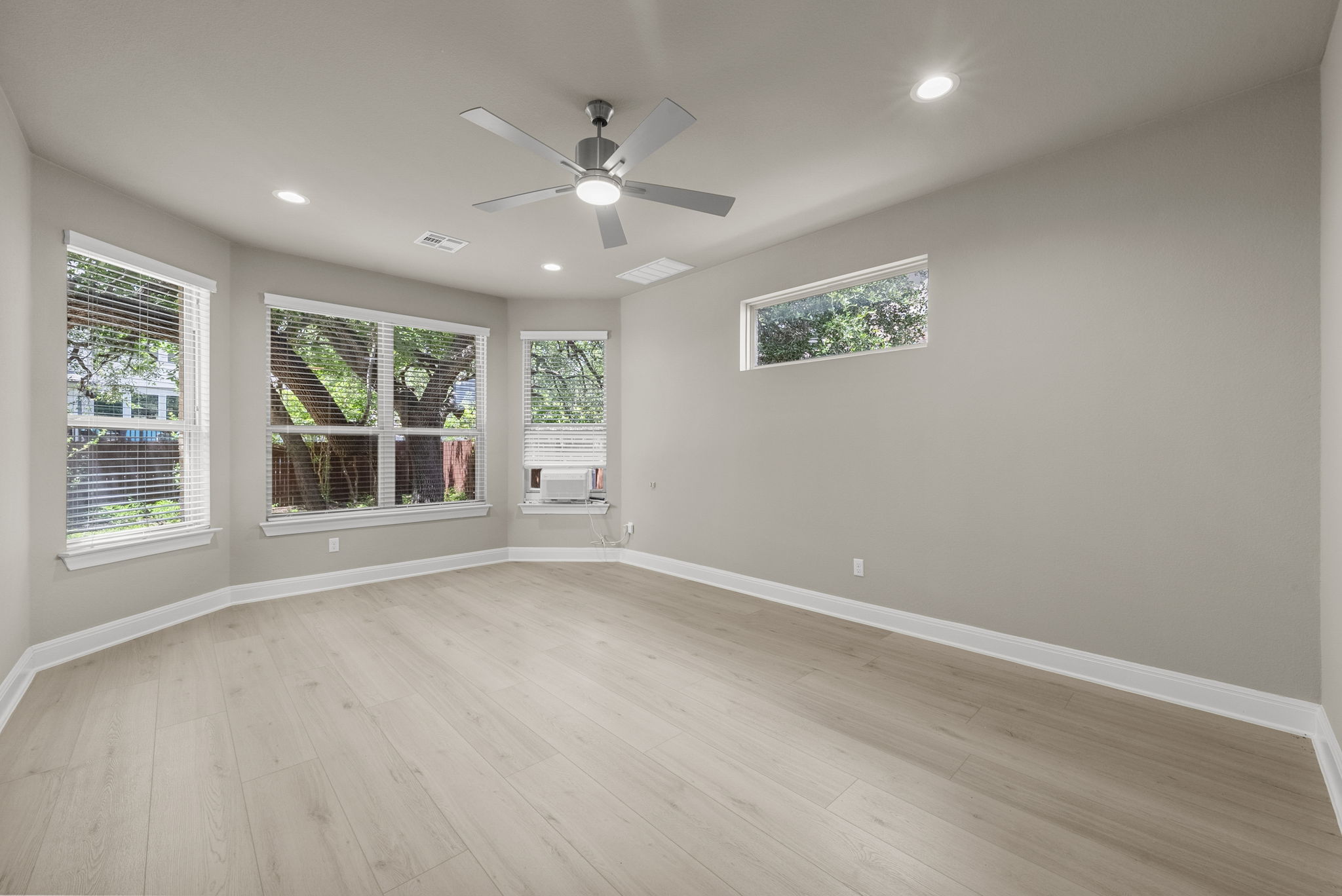 4401 Trinity Woods Street Leander, TX 78641 - Photo 17 of 37 A spacious room with light hardwood flooring offers ample natural light and modern ceiling lighting.