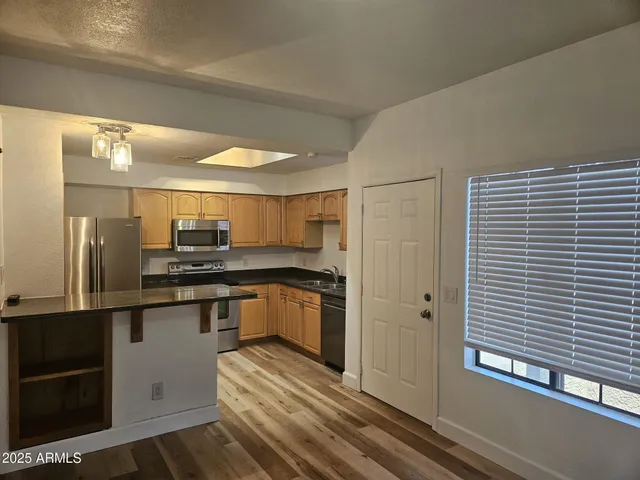 a kitchen with stainless steel appliances granite countertop a refrigerator and a sink