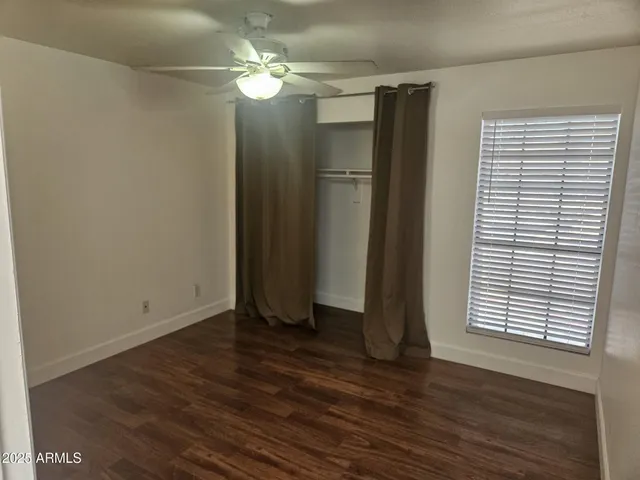 an empty room with wooden floor and a window