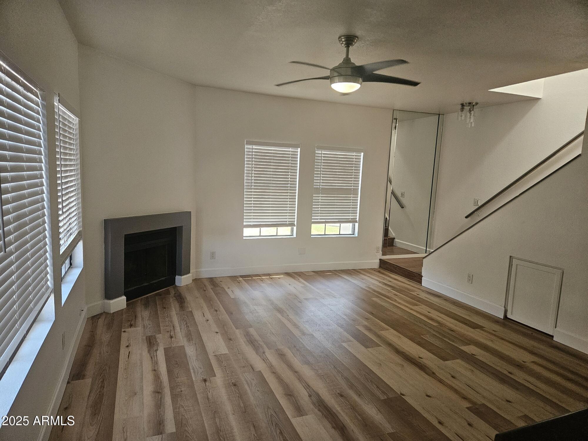 1245 West 1st Street, Unit 127 Tempe, AZ 85281 - Photo 4 of 15 a view of an empty room with wooden floor fireplace and a window