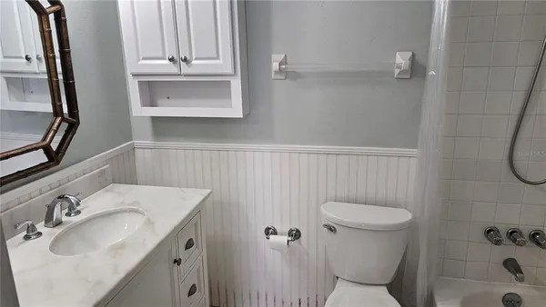 a bathroom with a sink a toilet and a mirror