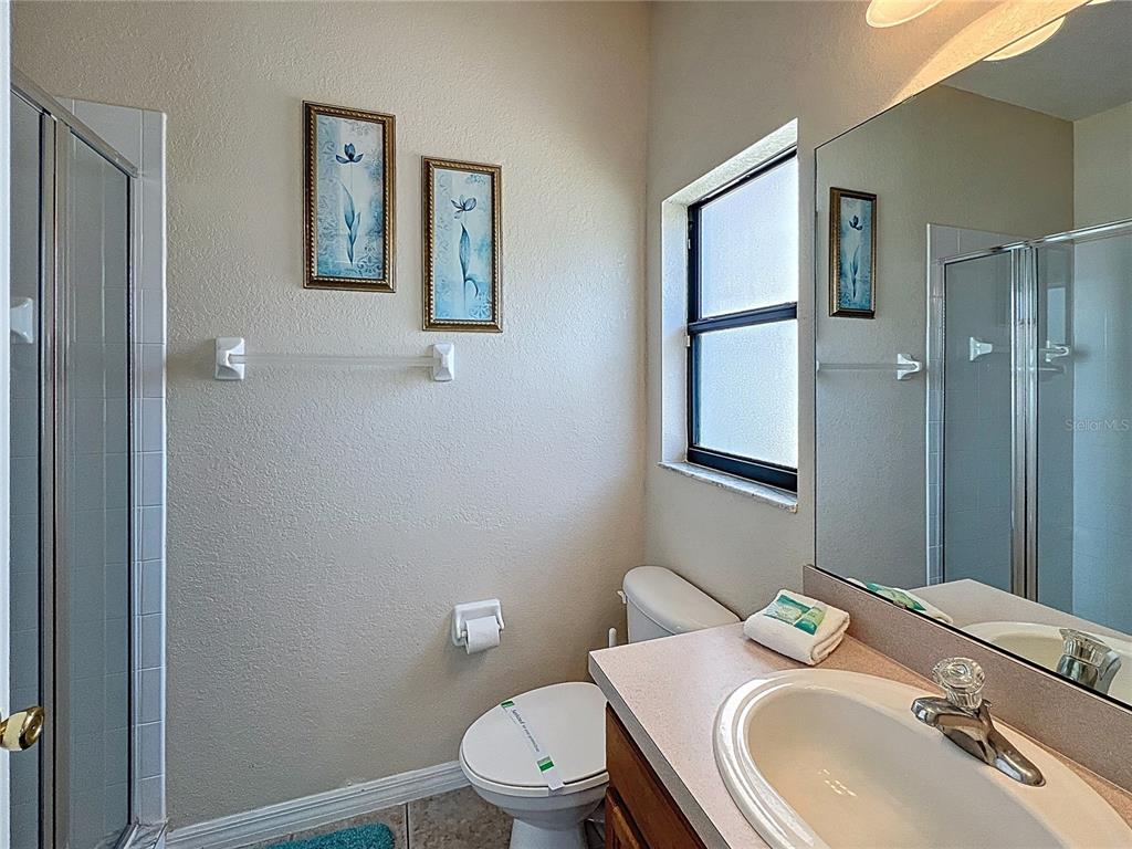 102 Sandy Point Way Clermont, FL 34714 - Photo 12 of 33 a bathroom with a granite countertop toilet sink and mirror