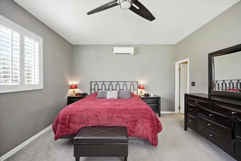 a bed room with a bed furniture and a flat tv screen