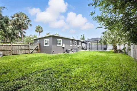 an aerial view of residential houses with outdoor space and trees
