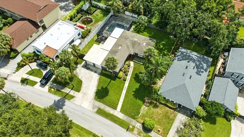 an aerial view of residential houses with outdoor space and trees
