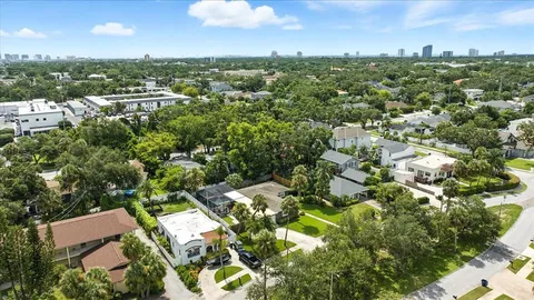 an aerial view of residential houses with outdoor space and trees