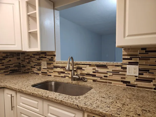 a kitchen with sink a stove and cabinets