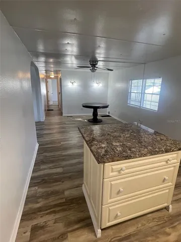 a kitchen with granite countertop a stove top oven and cabinets