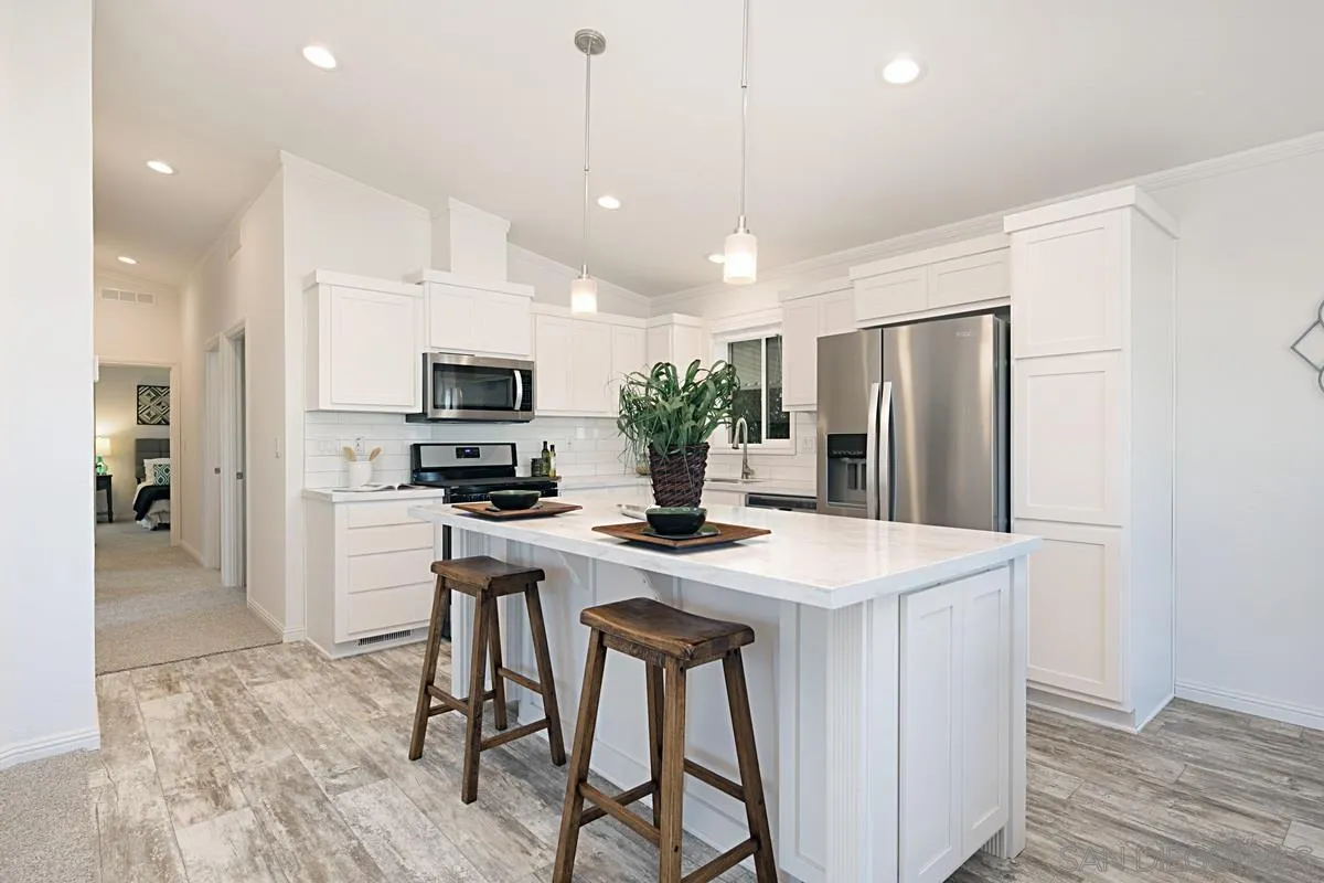 1120 East Mission Road, Unit 7 Fallbrook, CA 92028 - Photo 8 of 24 a kitchen with stainless steel appliances granite countertop a refrigerator a oven a sink a stove a dining table and chairs