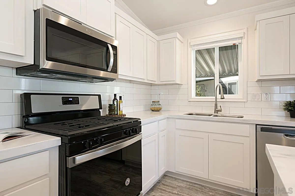 1120 East Mission Road, Unit 7 Fallbrook, CA 92028 - Photo 9 of 24 a kitchen with cabinets stainless steel appliances a sink and a window