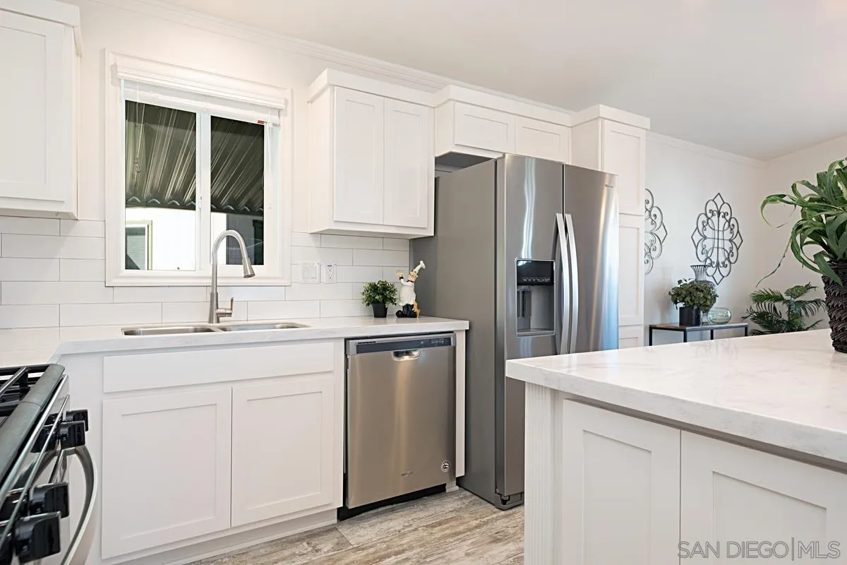 1120 East Mission Road, Unit 7 Fallbrook, CA 92028 - Photo 10 of 24 a kitchen with stainless steel appliances a refrigerator sink and cabinets