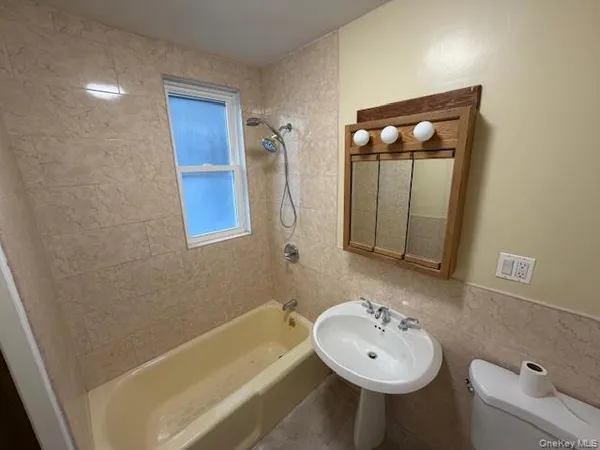 a bathroom with a bathtub a sink and a mirror