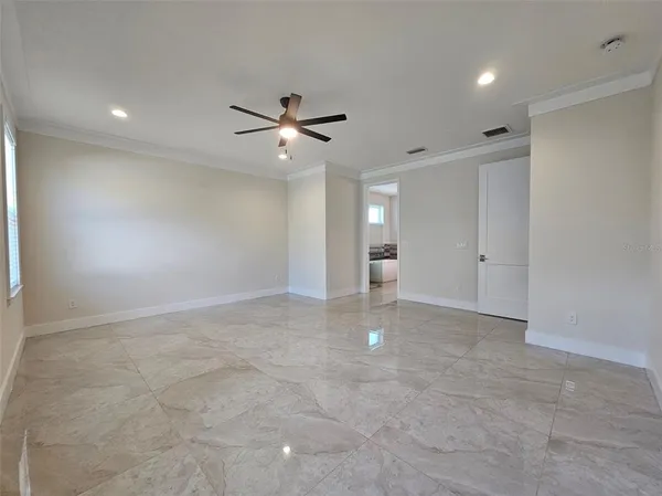 an empty room with fan and windows