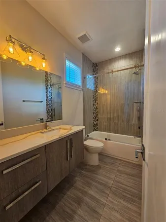 a bathroom with a granite countertop sink toilet and shower