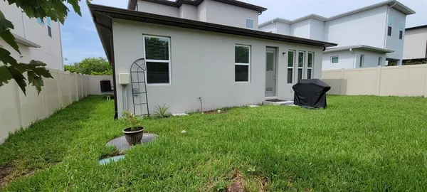 a backyard of a house with table and chairs