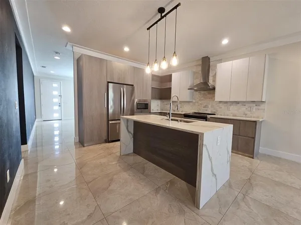 a kitchen with kitchen island a sink stainless steel appliances and cabinets