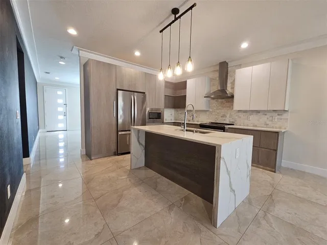 a kitchen with kitchen island a sink stainless steel appliances and cabinets