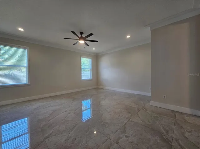 an empty room with windows and fan