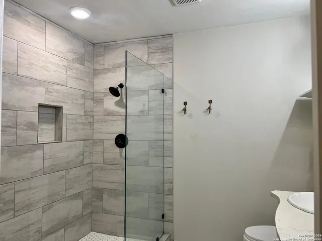 a bathroom with a shower a toilet and sink