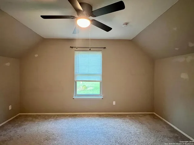 an empty room with a window and a fan
