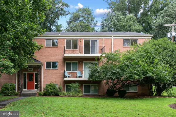 a view of a house with brick walls and a large tree