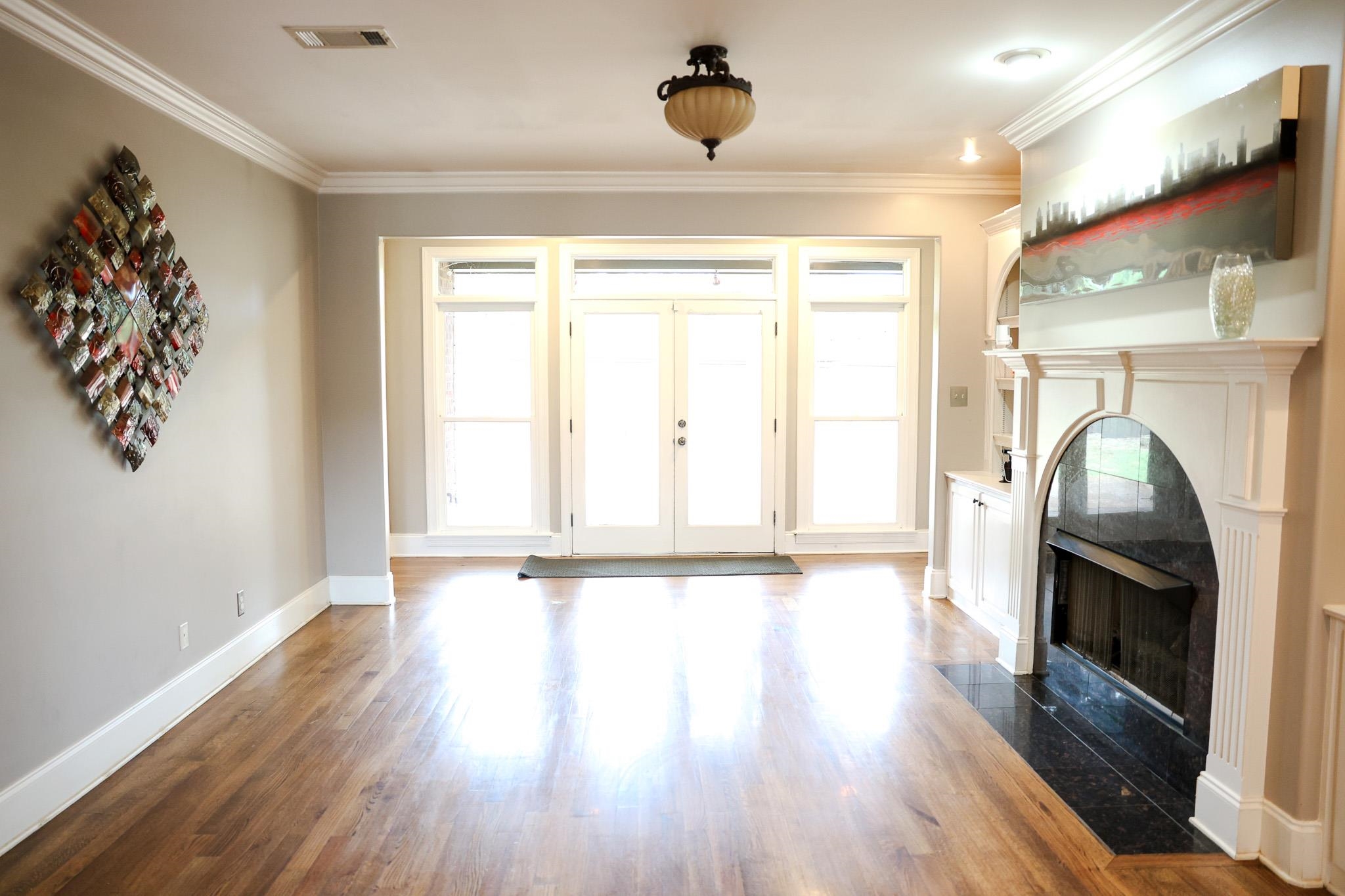 649 Ridge Springs Road Collierville, TN 38017 - Photo 7 of 35 Unfurnished living room with ornamental molding, a high end fireplace, french doors, and wood finished floors