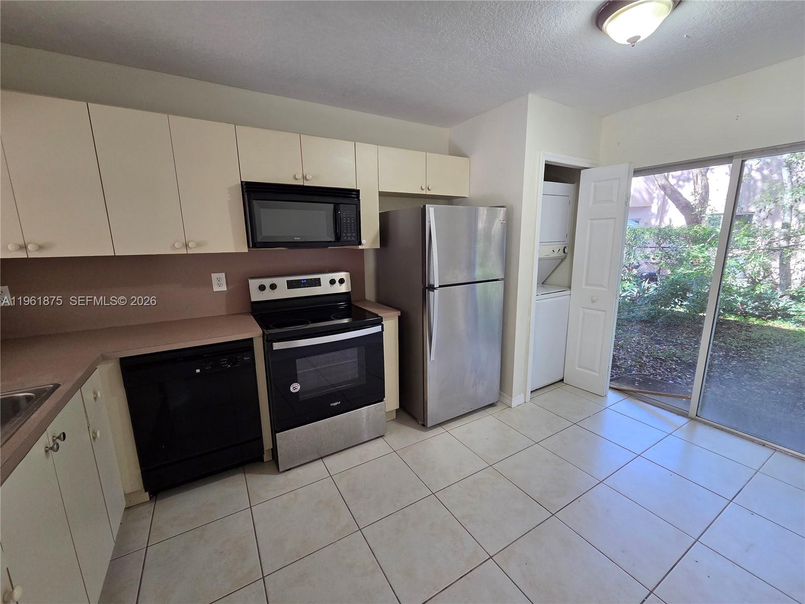 1251 Southeast 29th Street, Unit 10326 Homestead, FL 33035 - Photo 3 of 17 a kitchen with a refrigerator a stove a microwave and a sink