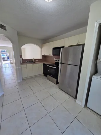 a kitchen with stainless steel appliances a refrigerator and a stove top oven
