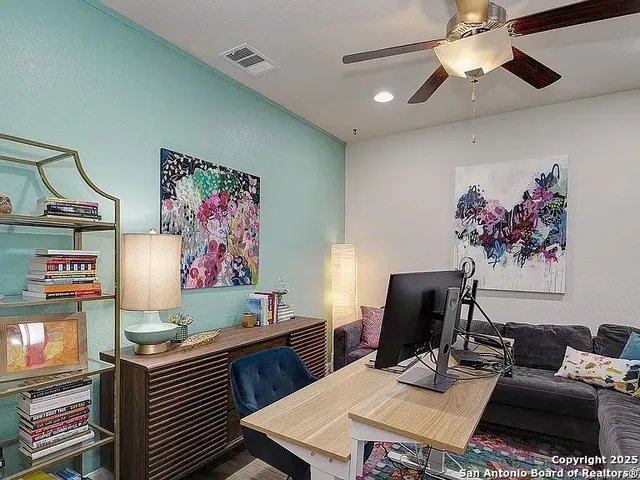 a work room with furniture and paintings on the wall