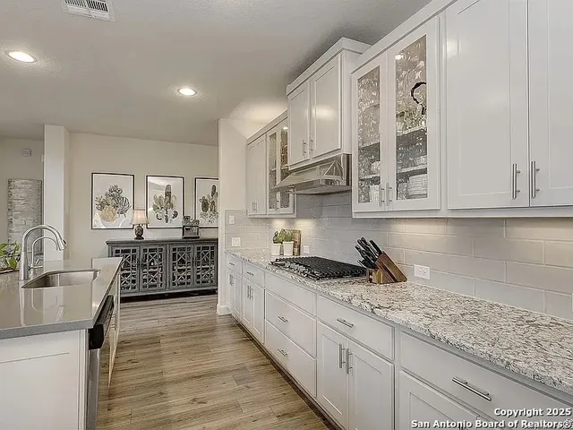 a kitchen with stainless steel appliances granite countertop a sink stove and cabinets