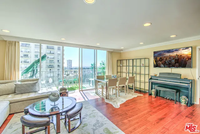 a living room with furniture a fireplace and a large window