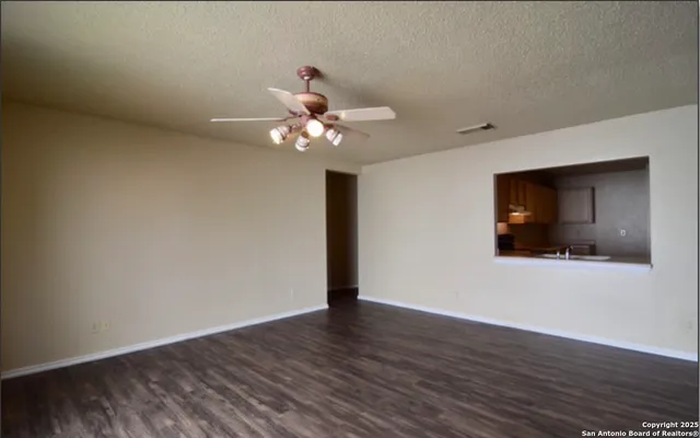 a view of an empty room with wooden floor