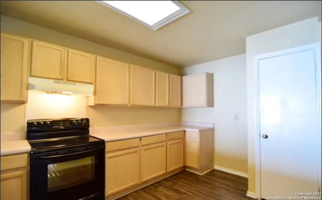 a kitchen with cabinets appliances and a window