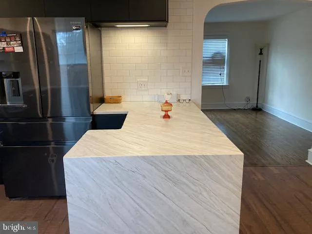 a large white bed in a small room next to a window