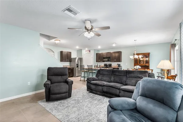a living room with furniture ceiling fan and a rug