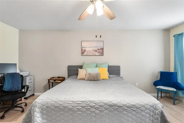 a bedroom with a bed a chair and a potted plant