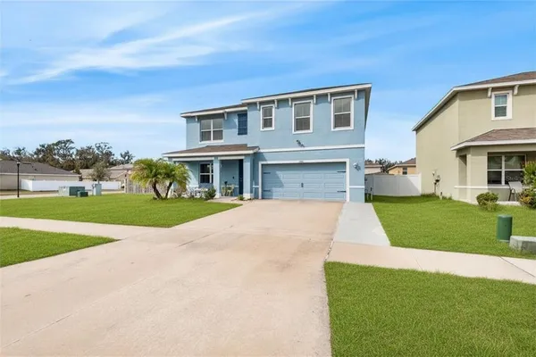 a front view of a house with a yard and trees