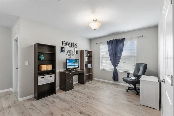 a view of a workspace with furniture and a window
