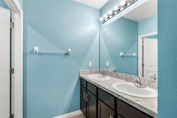 a bathroom with a double vanity sink and a mirror