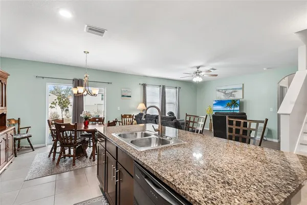 a kitchen with kitchen island granite countertop a sink table and chairs