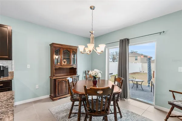 a dining room with furniture a chandelier and window