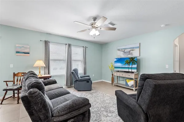 a living room with furniture a ceiling fan and a window