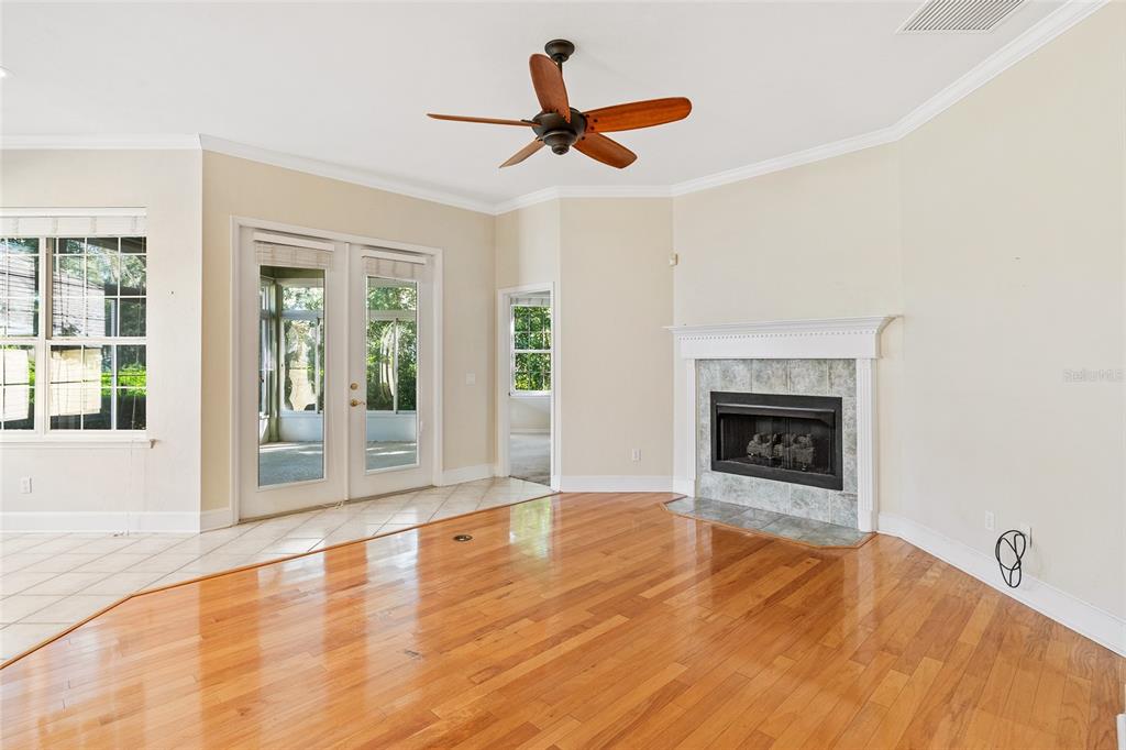 10526 Northwest 32nd Road Gainesville, FL 32606 - Photo 20 of 48 a view of empty room with wooden floor and fireplace