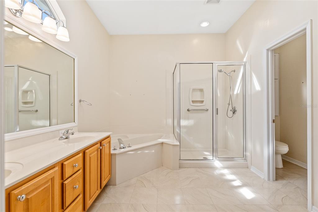10526 Northwest 32nd Road Gainesville, FL 32606 - Photo 30 of 48 a spacious bathroom with a double vanity sink a mirror and a bathtub