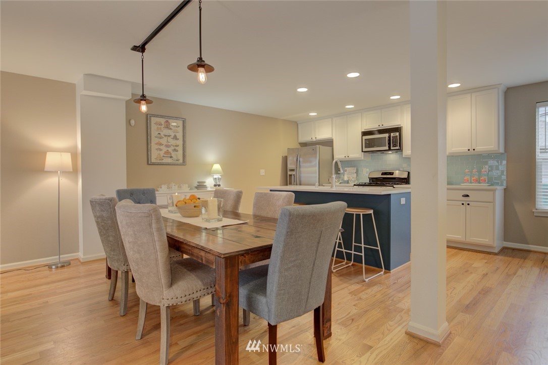 10136 Holman Road Northwest, Unit A Seattle, WA 98133 - Photo 8 of 27 a dining area with stainless steel appliances kitchen island granite countertop a dining table chairs and a refrigerator