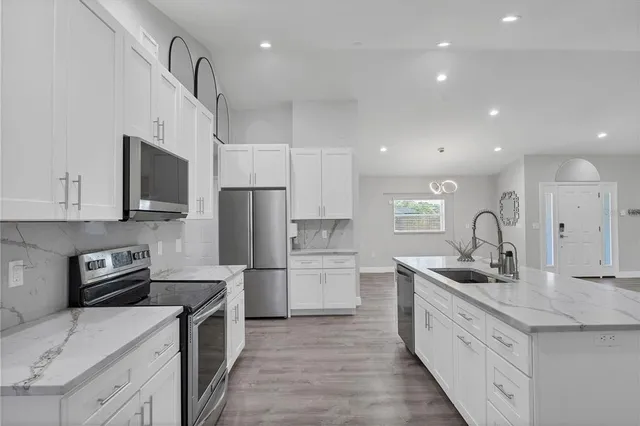 a kitchen with refrigerator cabinets and a sink