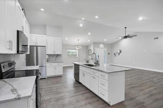 a kitchen with white cabinets and sink